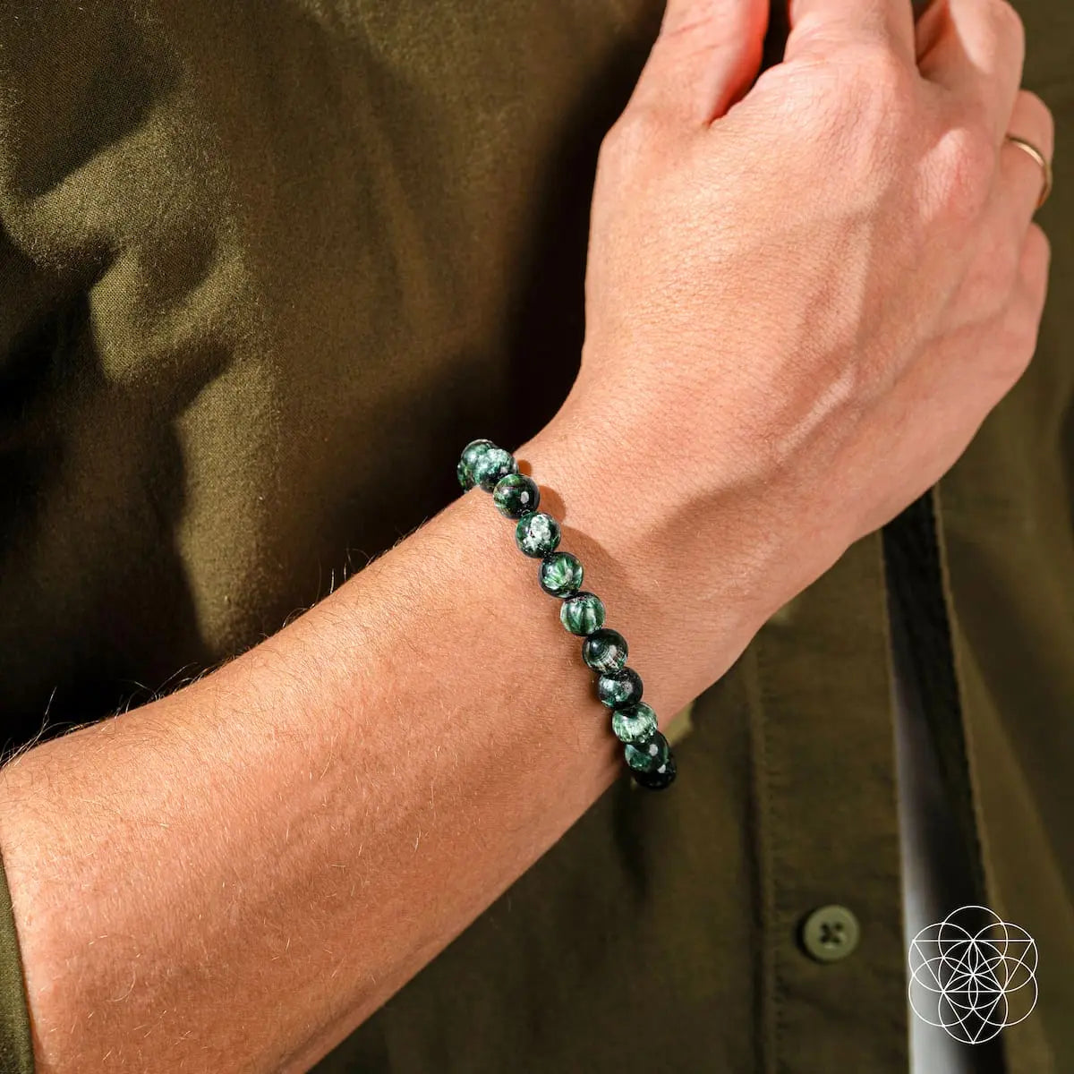 Seraphinite bracelet of transformation by Conscious Items featuring a rare angel energy pendant with intricate green and silver details.