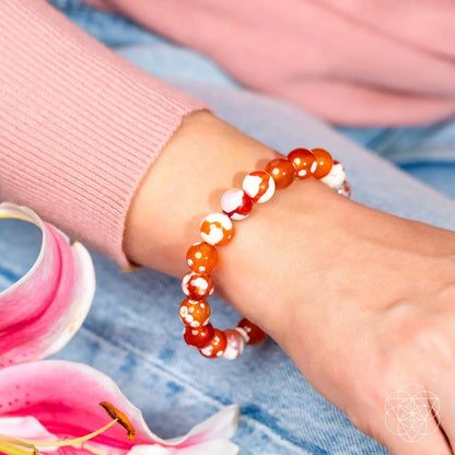 Feminine Force Carnelian Orca Agate bracelet by Conscious Items featuring polished orange and black patterned agate beads.