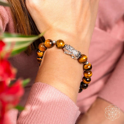 Conscious Items Fortune Flows Tiger’s Eye and Pixiu bracelet featuring polished beads and intricate charm for good luck.
